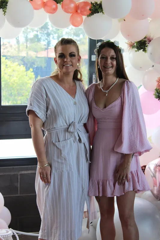 Two guests beneath the balloon arch