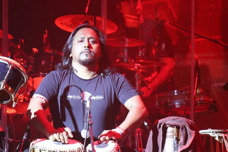 Tabla player mid-performance under red light